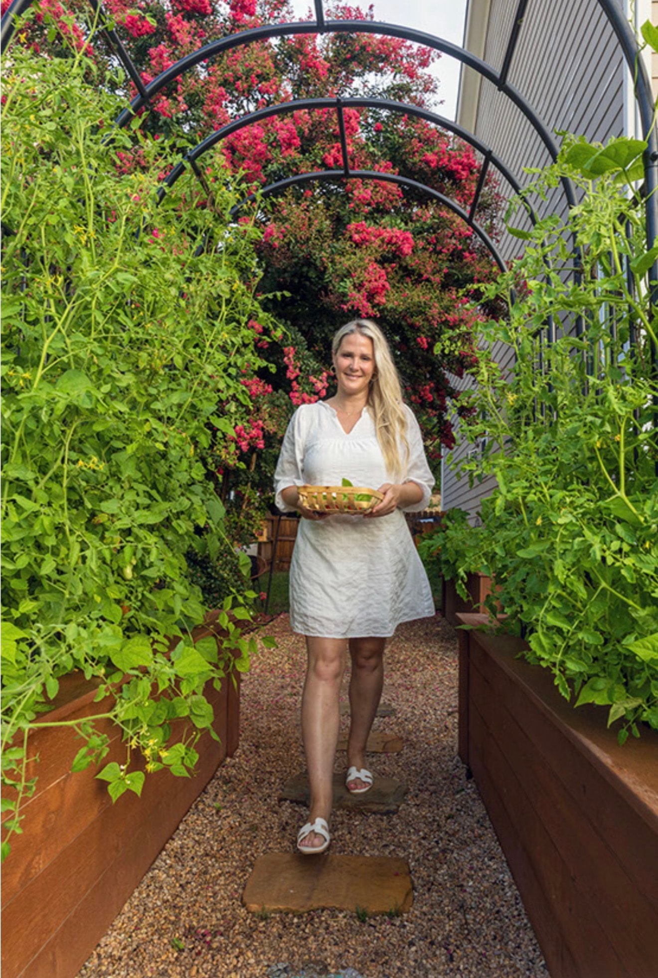 Corinne Beirne standing in her garden arch with fresh harvest